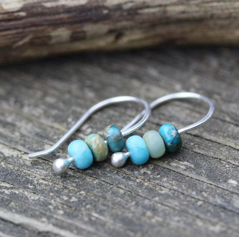 Minimalistische zilveren oorbellen met turquoise kralen