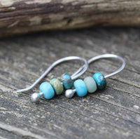 Minimalistische zilveren oorbellen met turquoise kralen
