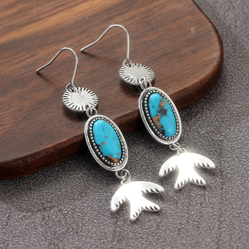 Zilveren oorbellen met ovale turquoise en vogelhanger