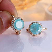 Gouden clip-oorbellen met ronde turquoise steen en zirkonia