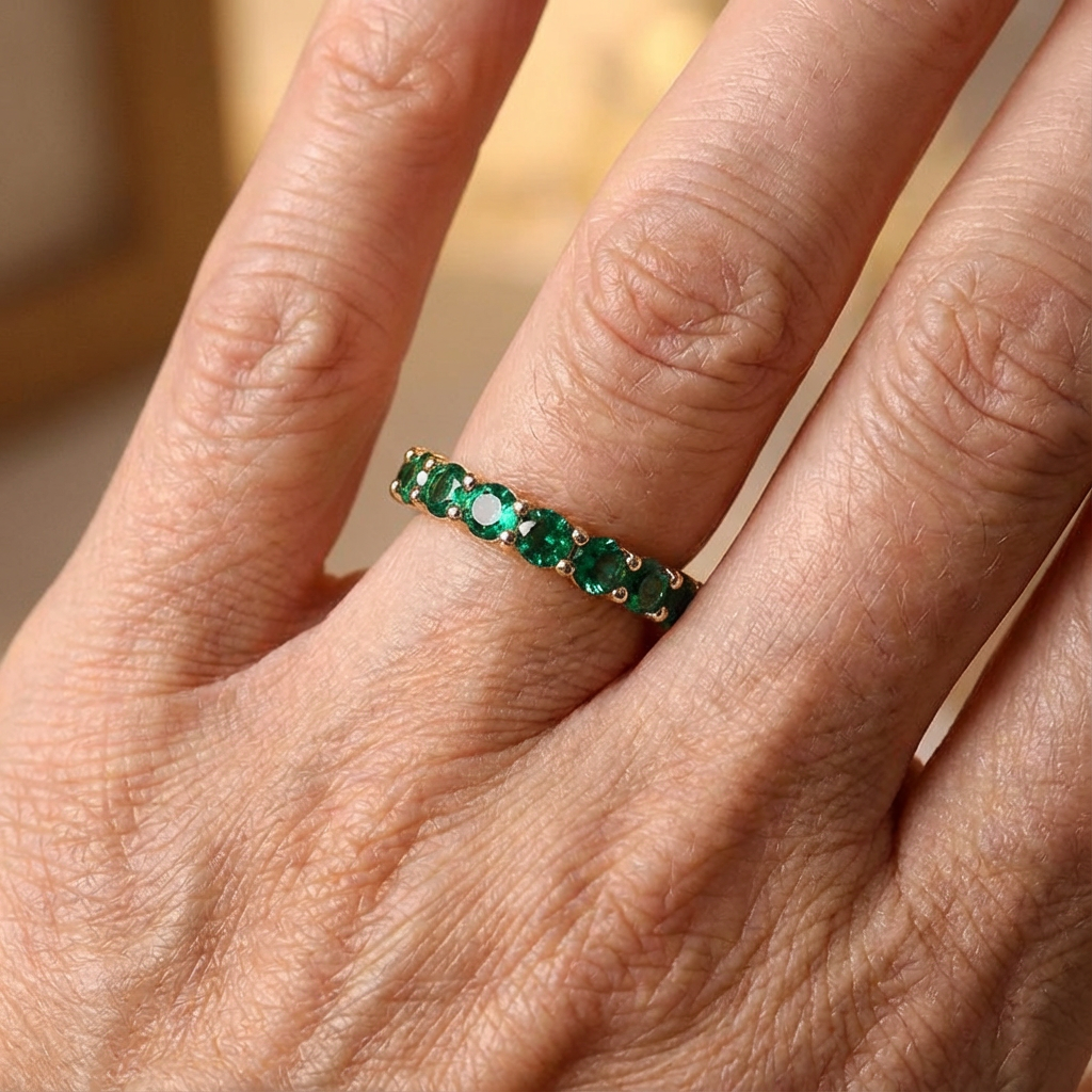 Gouden eternity-ring met groene edelstenen