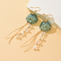 Gouden tassel oorbellen met groene glazen steen