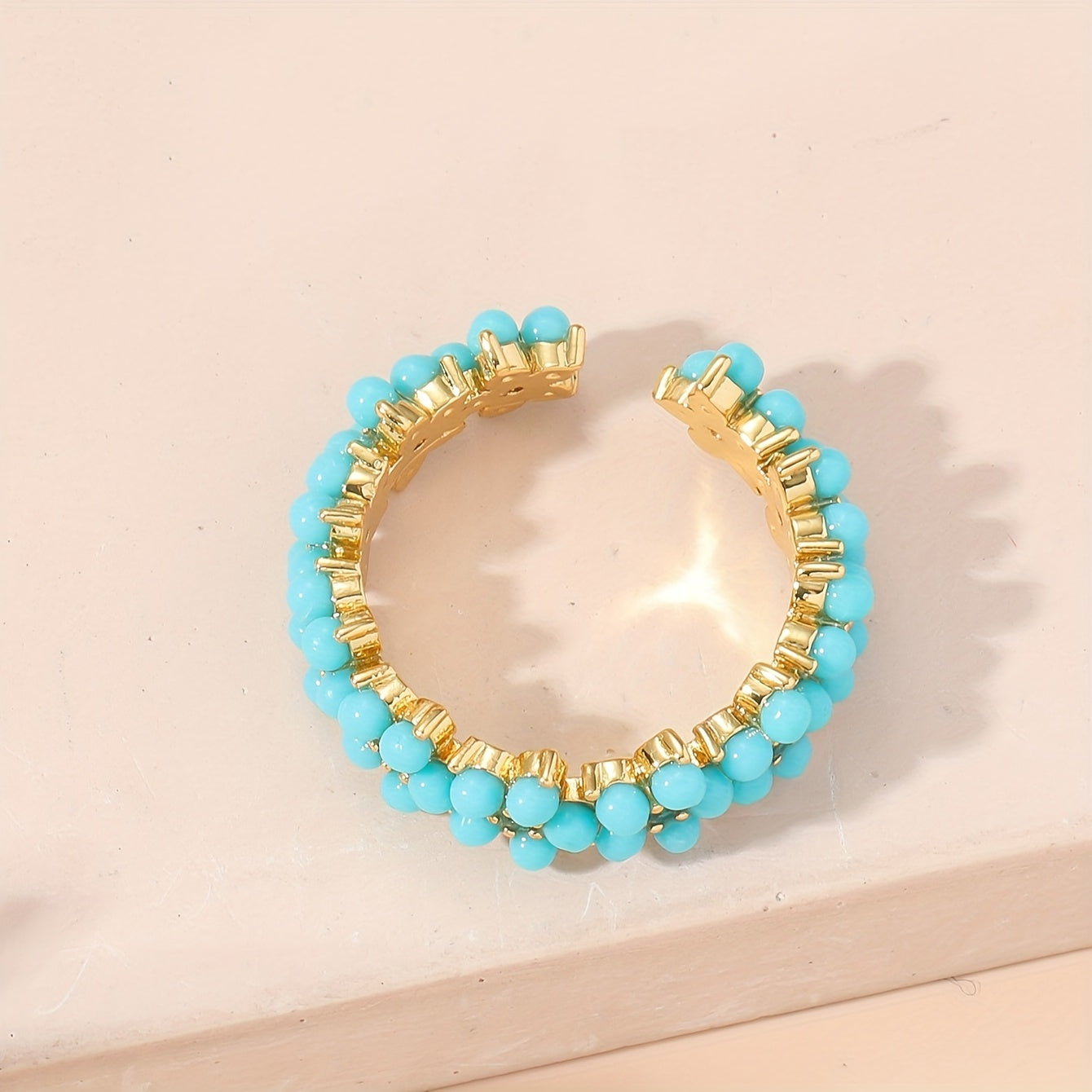 Gouden ring met turquoise kralen bloemmotief