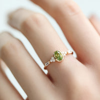 Gouden ring met ovale peridot en diamantaccenten