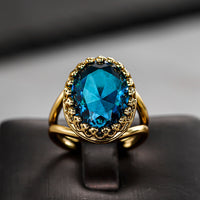 Gouden vintage ring met ovale blauwe edelsteen in kroonzetting