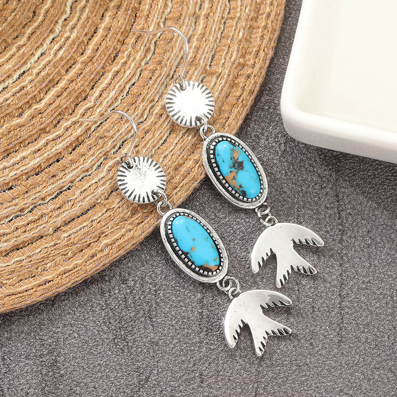 Zilveren oorbellen met ovale turquoise en vogelhanger