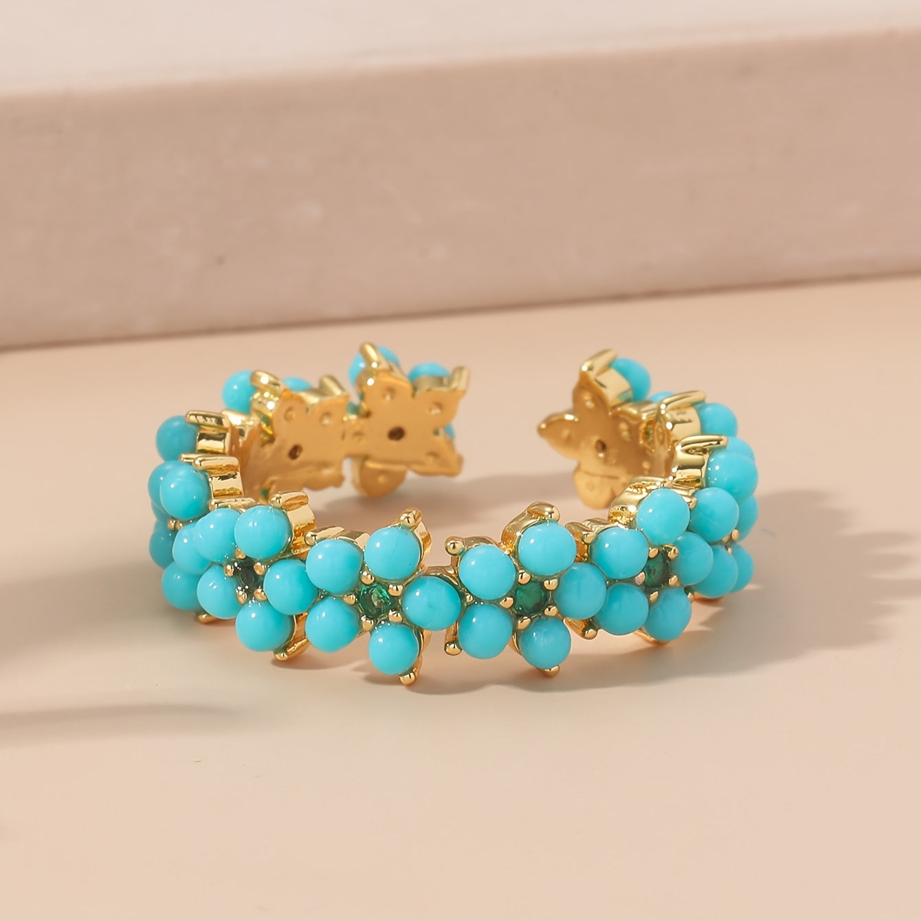 Gouden ring met turquoise kralen bloemmotief