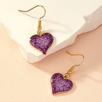 Gouden oorbellen met paars glitterhart