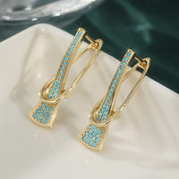 Gouden oorbellen met turquoise en gekruist design