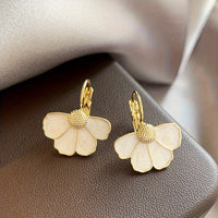 Gouden oorbellen met witte parelmoer bloem