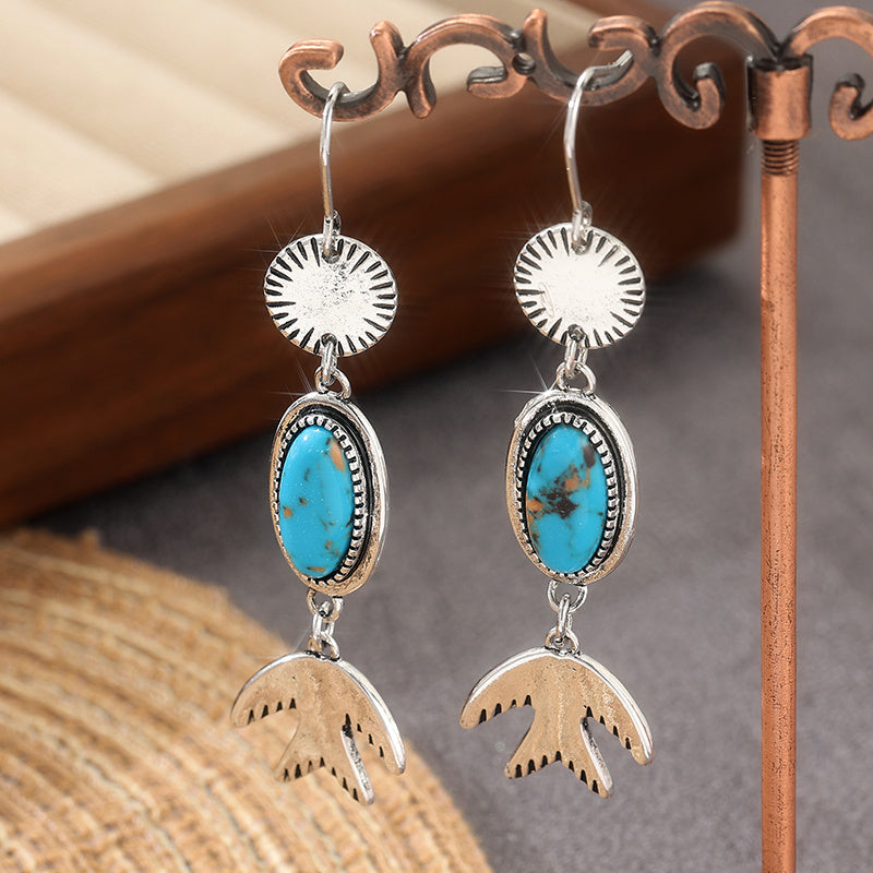 Zilveren oorbellen met ovale turquoise en vogelhanger