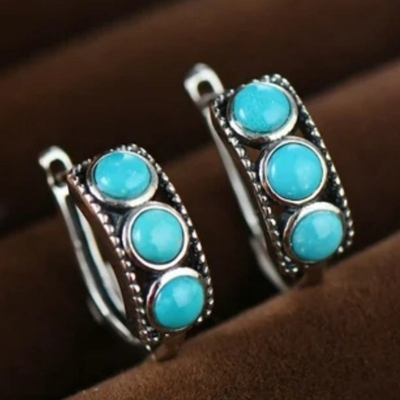 Zilveren huggie oorbellen met drie turquoise stenen
