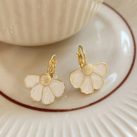 Gouden oorbellen met witte parelmoer bloem