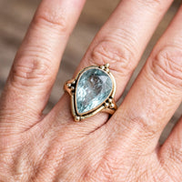 Gouden ring met peervormige lichtblauwe edelsteen
