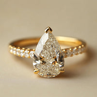 Gouden solitairering met peervormige zirkonia en pavé band