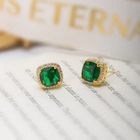 Gouden oorbellen met groene edelsteen en kristallen rand