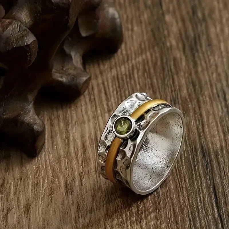Zilver-gouden gehamerde spinner ring met peridoot