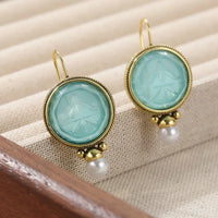 Gouden vintage oorbellen met turquoise intaglio en parel