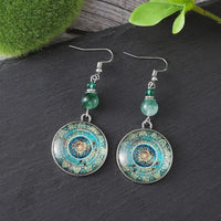 Bohemian oorbellen met mandala glasschijf en groene kralen