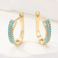 Gouden huggie-oorbellen met turquoise pavé
