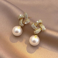 Gouden oorbellen met kristallen knoop en parelhanger