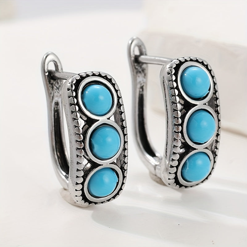 Zilveren huggie oorbellen met drie turquoise stenen