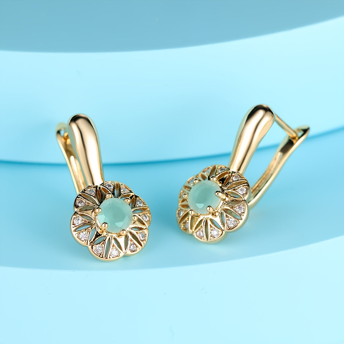 Gouden oorbellen met mintgroene steen en bloemrand