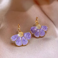 Gouden oorbellen met witte parelmoer bloem