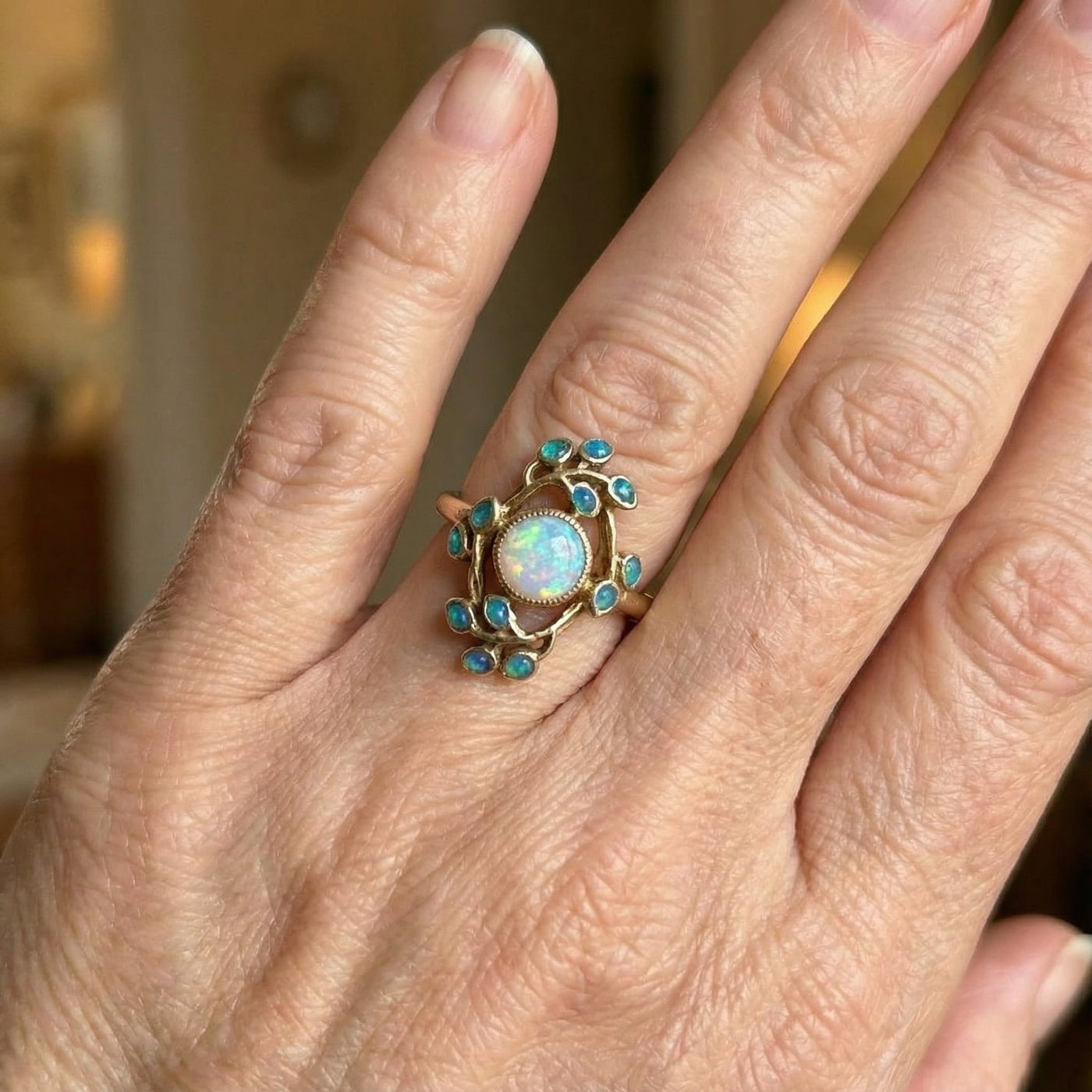 Gouden oorbellen met witte opaal en blauwe blaadjes