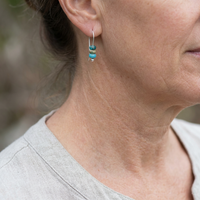 Minimalistische zilveren oorbellen met turquoise kralen