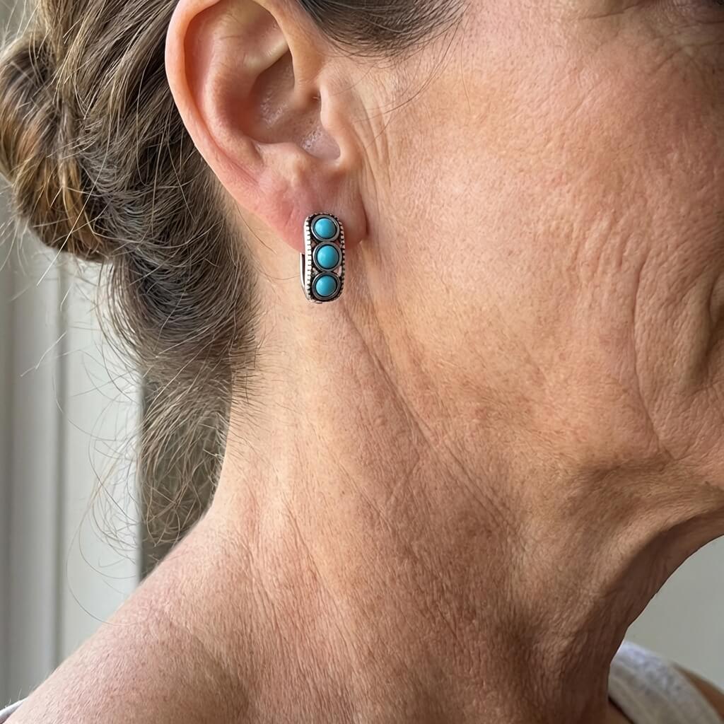 Zilveren huggie oorbellen met drie turquoise stenen