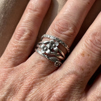 Zilveren ring met meerdere bloemen en bladeren