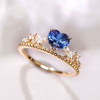 Gouden ring met blauwe ovale steen en tiaramotief