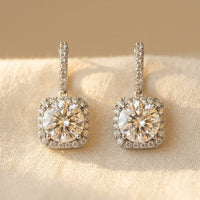 Zilveren hangoorbellen met ronde moissanite halo en kussenvorm