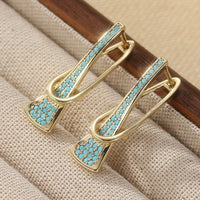 Gouden oorbellen met turquoise en gekruist design