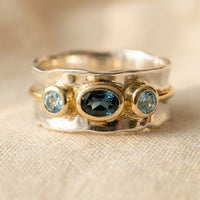 Zilveren ring met blauwe topaas en goudkleurige accenten