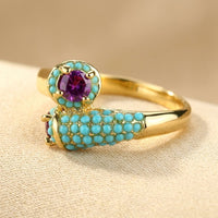 Gouden ring met turkoois en paarse edelsteen