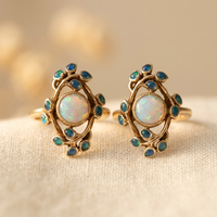 Gouden oorbellen met witte opaal en blauwe blaadjes